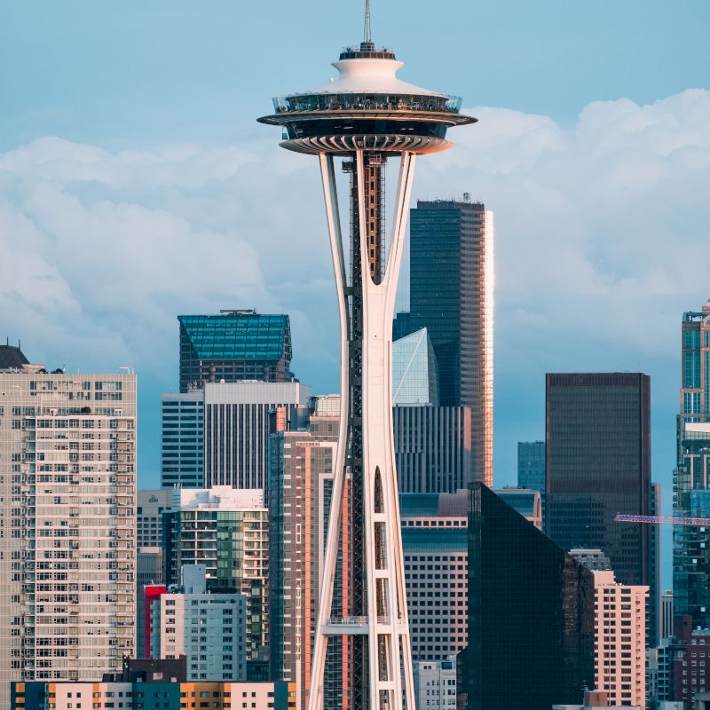 The image shows the iconic Space Needle in Seattle, Washington, with the city's skyline and various high-rise buildings in the background.