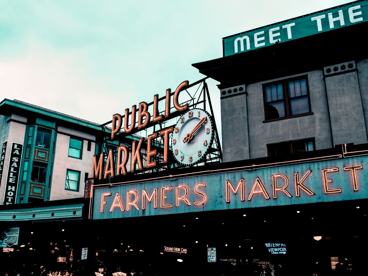 This image features the iconic neon signs at the entrance of Seattle's Pike Place Market, including "Public Market" and "Farmers Market".